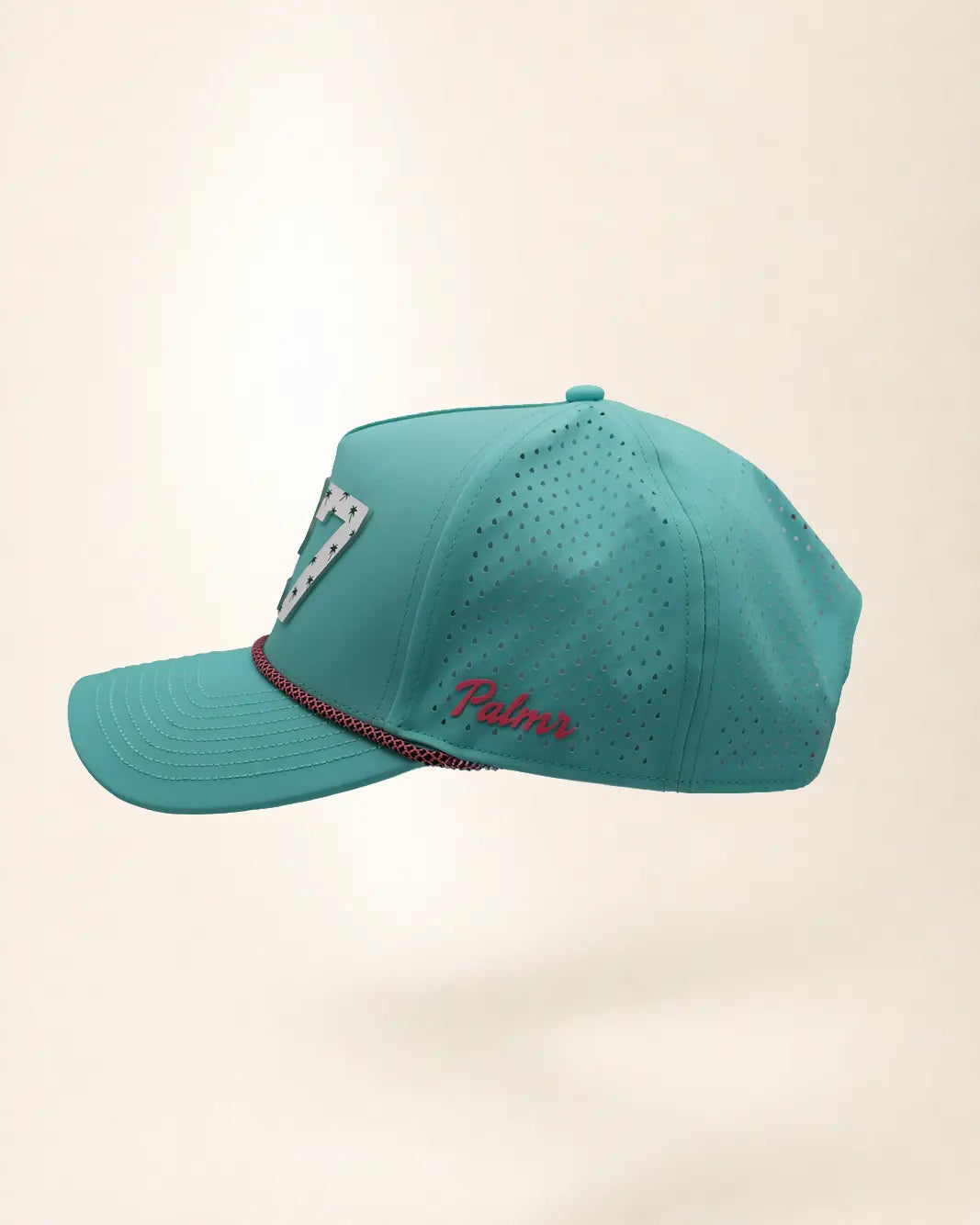 The 727 Signature Hat (Teal), left side view: pink Palmr script, perforated side panel, pink and black rope, edge of the white 727.
