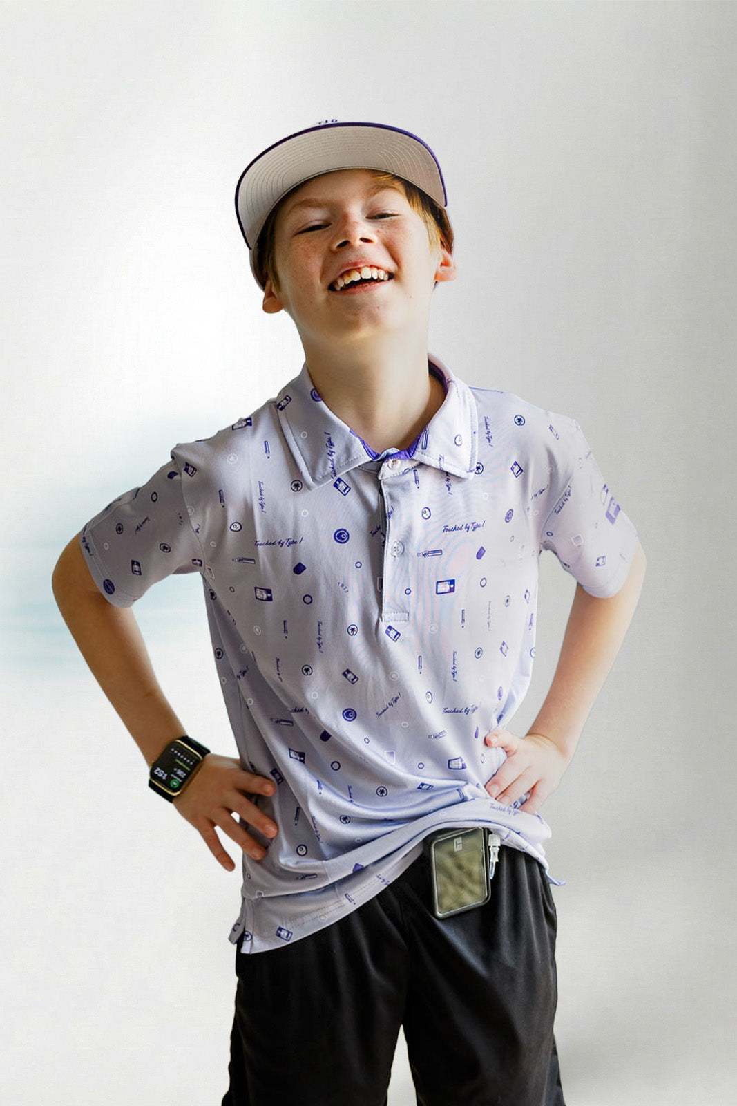 Child wearing a patterned polo shirt and cap on a plain background