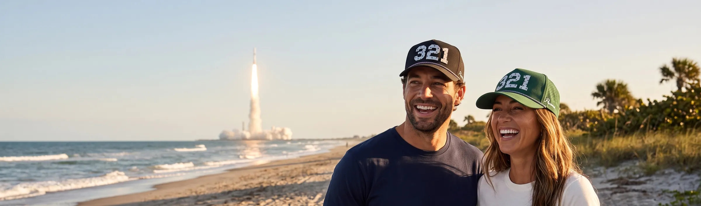 Couple wearing Palmr 321 Signature hats on the beach as a rocket launches over the Atlantic on Florida's Space Coast