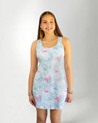 Girl wearing a tropical pattern dress against white background 