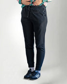 Person wearing black pants and black sneakers on a white background