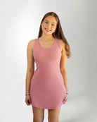 Woman wearing a pink dress against a plain background