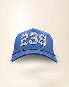 The 239 Signature Hat (Blue), front view: white raised 239 with small palm print on a blue crown, black and white rope along the brim.