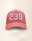 A pink perforated baseball cap showcasing the '239' State with a green and white patterned trim along the brim and white 'Palmr' script embroidery on the side, shown against a light beige background.
