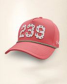 A pink perforated baseball cap showcasing the '239' State with a green and white patterned trim along the brim and white 'Palmr' script embroidery on the side, shown against a light beige background.