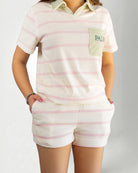 Person wearing light-colored striped shorts on a plain background