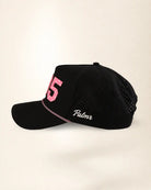 A black mesh baseball cap with a curved brim, featuring a pink embroidered number 5 on the front and the word 'Palmr' in white script on the side, set against a plain off-white background.