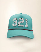 A teal baseball cap featuring the number '321' in white varsity-style lettering with palm patterns on the front, a thin white and pink chain detail across the visor, and 'Palmr' embroidered in pink on the side, set against a plain off-white background.