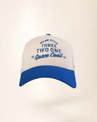 A baseball cap with an off-white crown and a royal blue brim, featuring blue embroidered text on the front that reads 'PALMR STYLE THREE TWO ONE 20 Space Coast 24'.