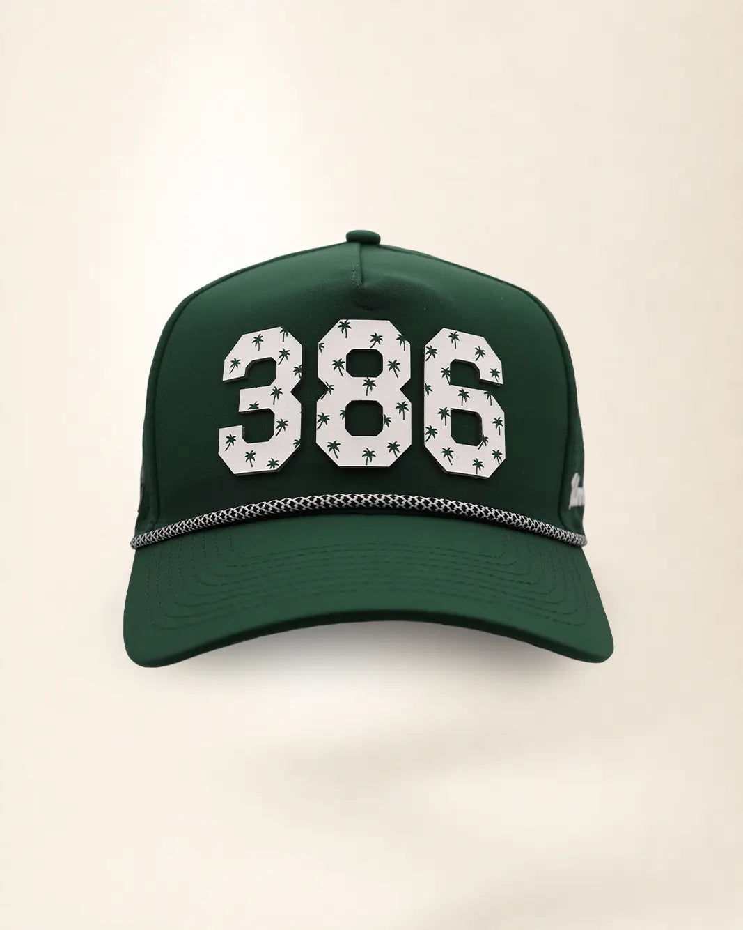 The 386 Signature Hat (Green): dark green rope snapback, white 386 with small green palm trees, black and white braided rope, perforated sides.