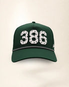 The 386 Signature Hat (Green): dark green rope snapback, white 386 with small green palm trees, black and white braided rope, perforated sides.