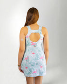 Girl wearing a tropical pattern dress against white background back view 