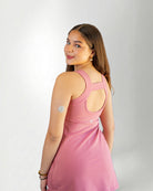 Woman wearing a pink dress against a plain background