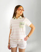 Person wearing a pastel striped outfit with a visible brand logo on a plain background