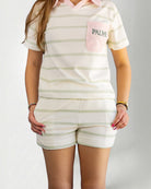Person wearing a striped polo shirt and shorts with 'PALMR' branding.