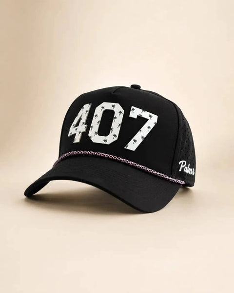 The 407 Signature Hat (Black): black rope snapback with 407 in white palm-print letters, pink braided rope on the brim, perforated sides.