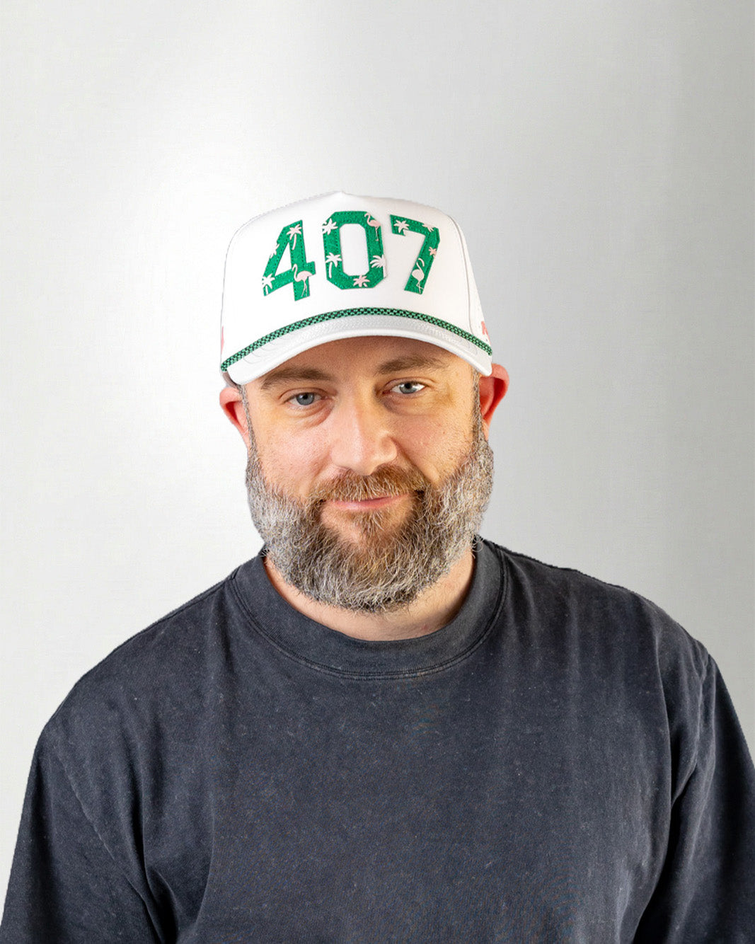 Man wearing a white cap with '407' printed on it against a plain background