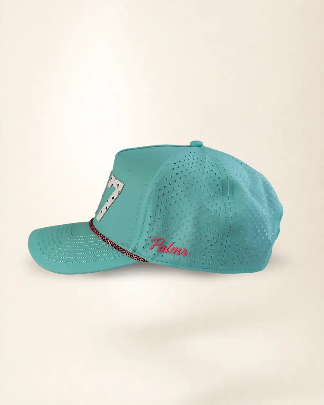 A turquoise blue perforated baseball cap with a curved brim, featuring a white and black patterned patch on the side and red embroidered script on the front panel.