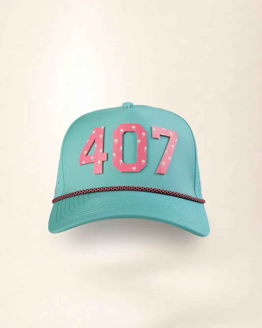 A turquoise baseball cap with pink '407' lettering on the front, decorated with small white stars, and a thin red-and-white patterned rope hanging from the brim, set against a plain beige background.