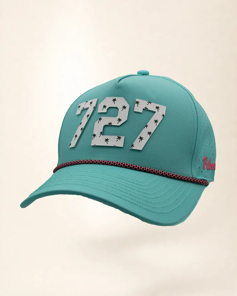 The 727 Signature Hat (Teal), three-quarter view: white raised 727 with small palm print on a teal rope snapback, pink and black rope, pink Palmr script.