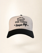 A two-tone baseball cap with a white crown and a black brim, featuring black embroidered text on the front that reads 'PALMR STYLE EIGHT ONE THREE 20 Tampa Bay 24'.