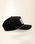 The 850 Signature Hat (Black), right side view: perforated side panel, palm badge, pink and white rope, edge of the white 850.