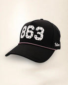 The 863 Signature Hat (Black), three-quarter view: white raised 863 with small palm print on a black rope snapback, pink and white rope, white Palmr script.