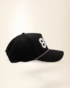 The 863 Signature Hat (Black), right side view: perforated side panel, palm badge, pink and white rope, edge of the white 863.