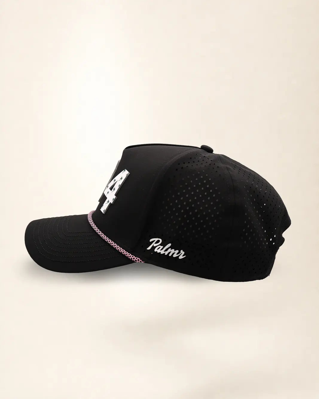 The 904 Signature Hat (Black), left side view: white Palmr script, perforated side panel, pink and white rope, edge of the white 904.