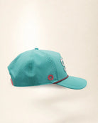 The 904 Signature Hat (Teal), right side view: perforated side panel, pink palm badge, pink and black rope on the brim, edge of the white 904.