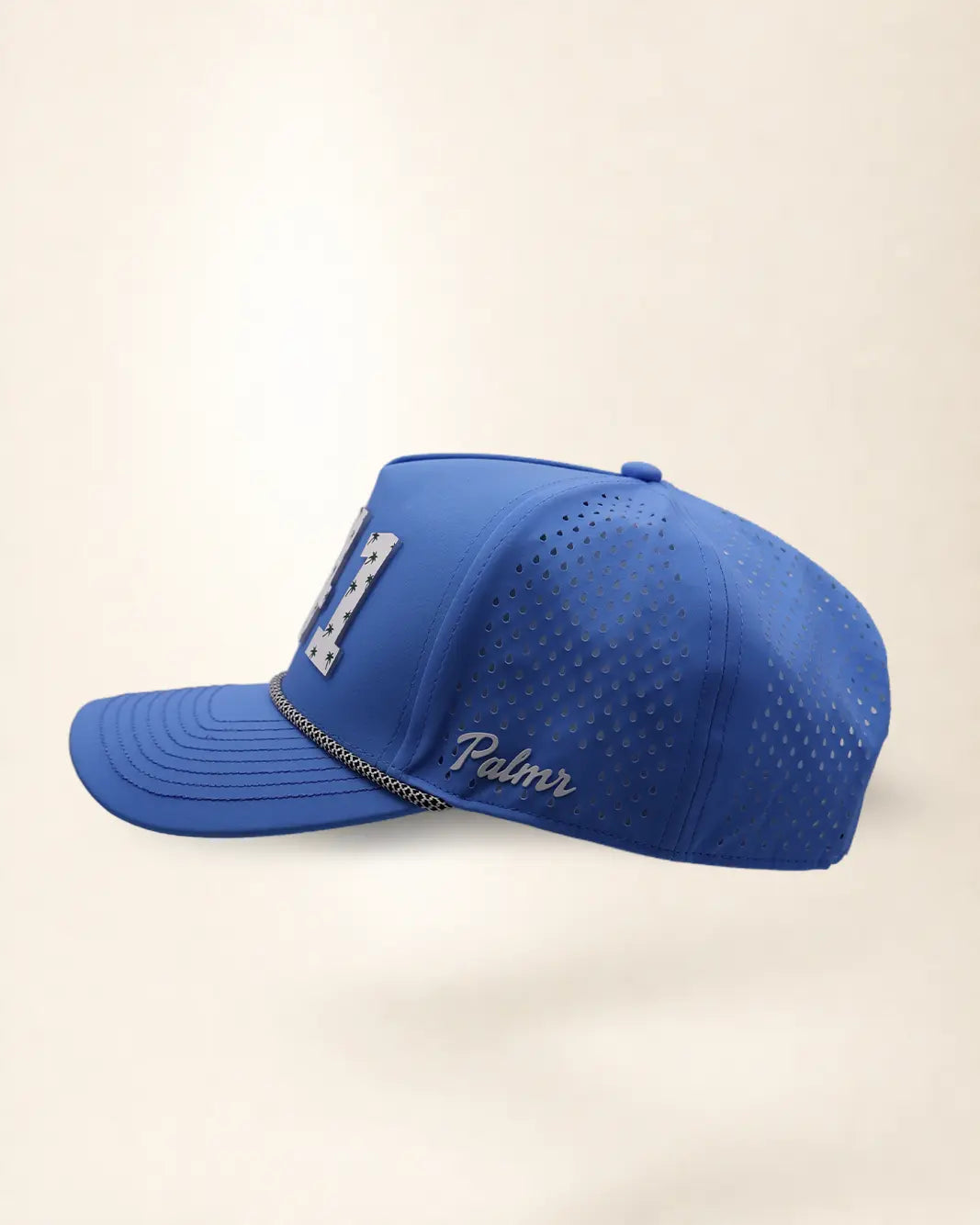 The 941 Signature Hat (Blue), left side view: white Palmr script, perforated side panel, black and white rope, edge of the white 941.