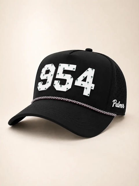 The 954 Signature Hat (Black): black rope snapback, white 954 with small green palm trees, pink and black braided rope, perforated sides.
