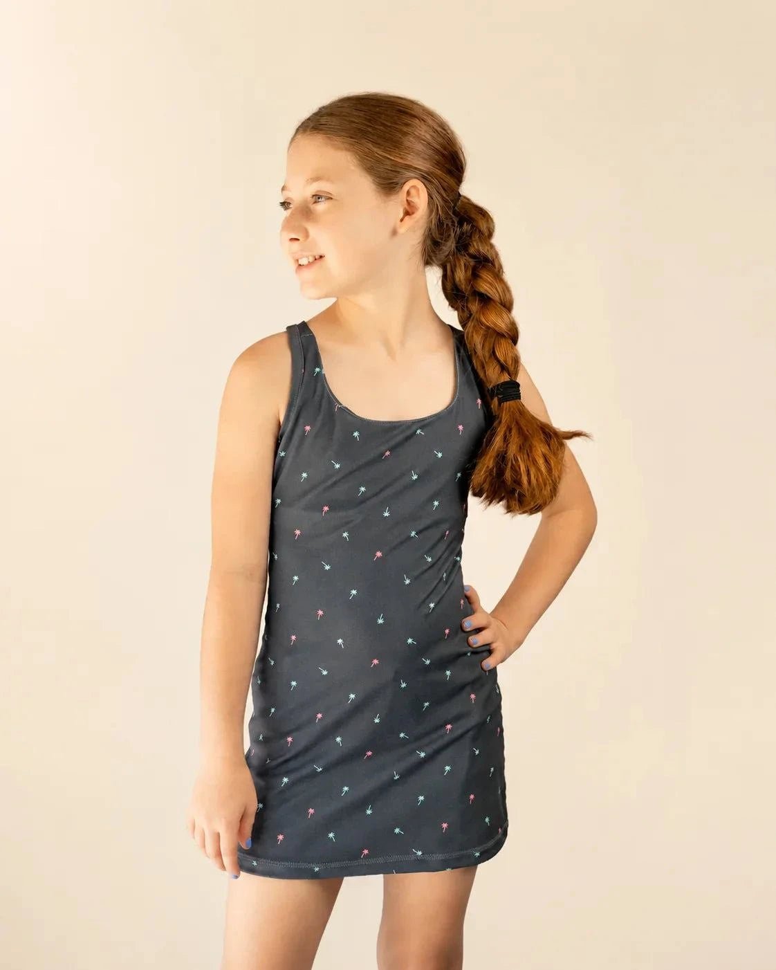 Girl wearing Ace Kids Dress in Palm Icon Night with palm print on dark charcoal background at sunset dinner outdoors