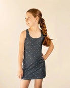 Girl wearing Ace Kids Dress in Palm Icon Night with palm print on dark charcoal background at sunset dinner outdoors