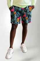 Person wearing colorful tropical shorts with a white background