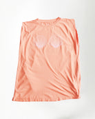 Peach-colored sleeveless top with shell designs on a white background