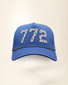 The 772 Signature Hat (Blue), front view: white raised 772 with small palm print on a blue crown, black and white rope along the brim.
