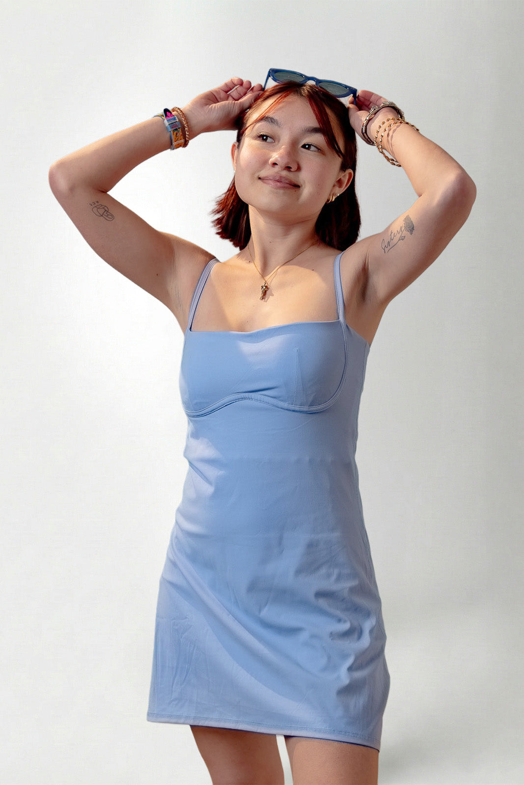Woman wearing a light blue dress against a plain background