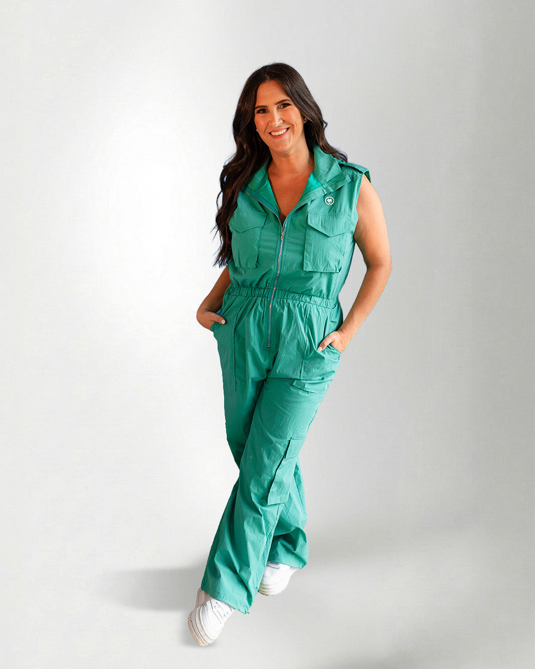 Woman wearing a green jumpsuit on a gray background