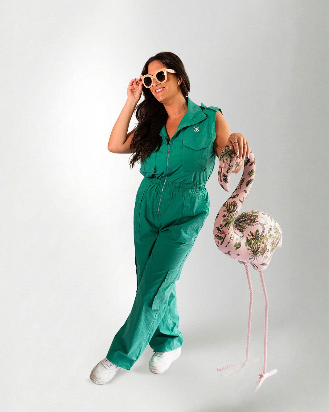 Woman wearing a green jumpsuit on a gray background