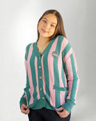 Woman wearing a green and pink striped cardigan on a white background