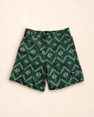 Men wearing The Club Palm Hybrid Swim Shorts with palm tree and geometric diamond print by the pool and patio.