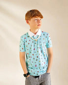 The Palmr Coastal Bay Kids Polo teal polo shirt with white collar and palm icons for active children