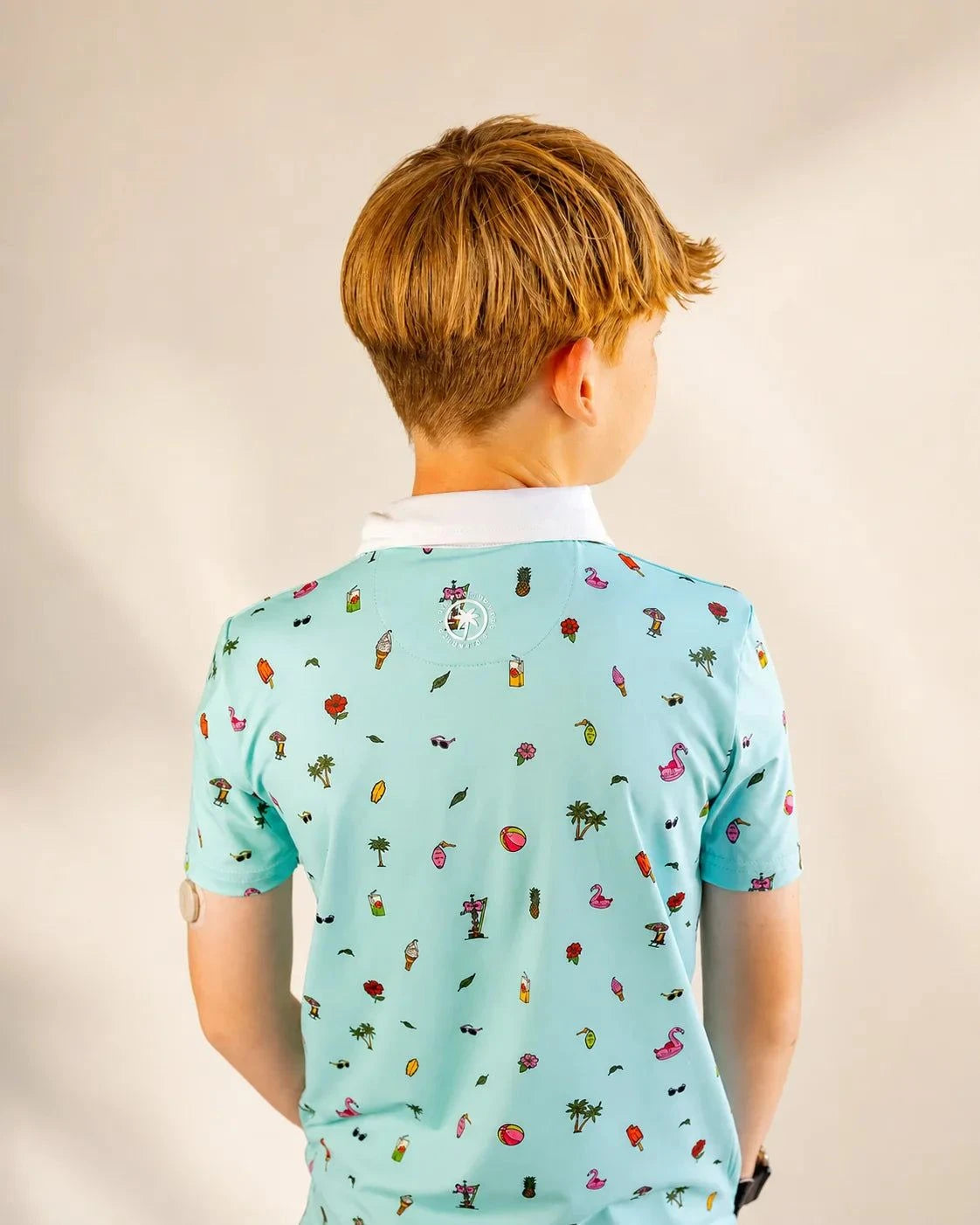 The Palmr Coastal Bay Kids Polo teal mini version with white collar and palm icons in athletic fit