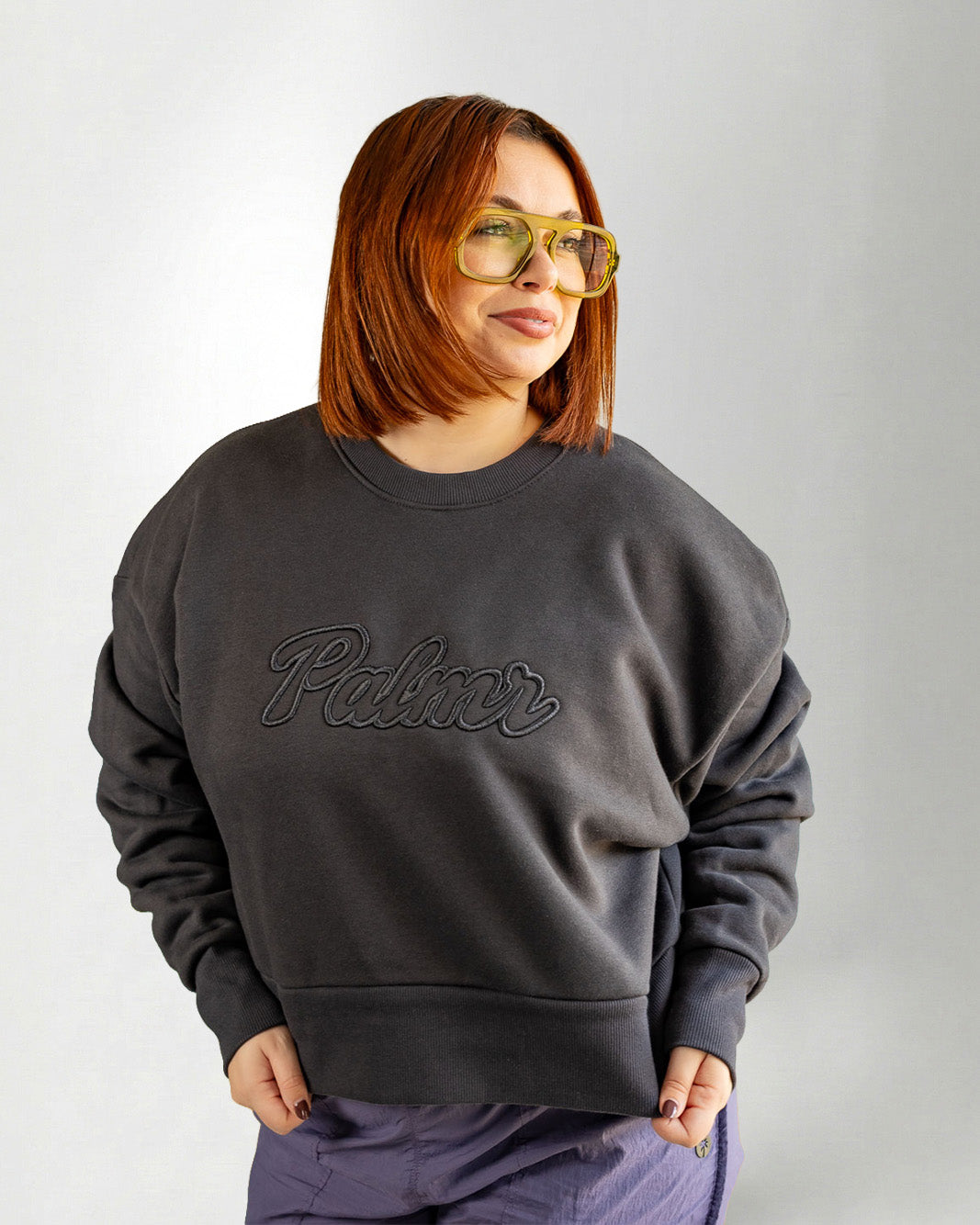 Person wearing a dark gray sweatshirt with 'Palmr' branding on a light gray background