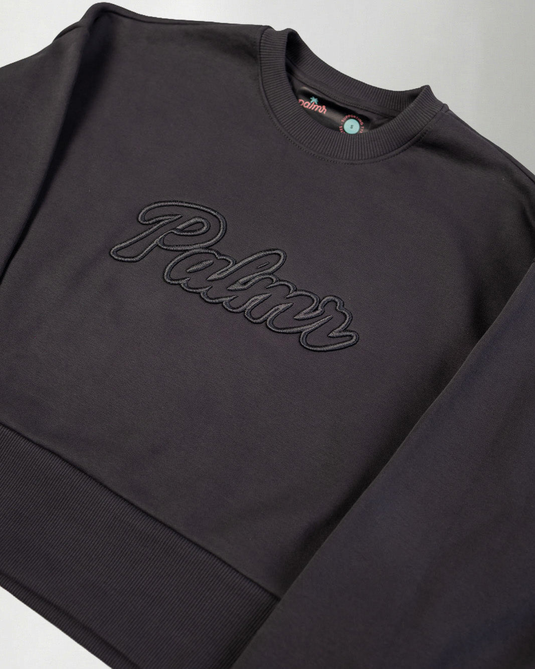 Dark gray sweatshirt with 'Palmr' branding on a light gray background