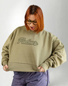 Person wearing a green sweatshirt with 'Palmr' text on a plain background