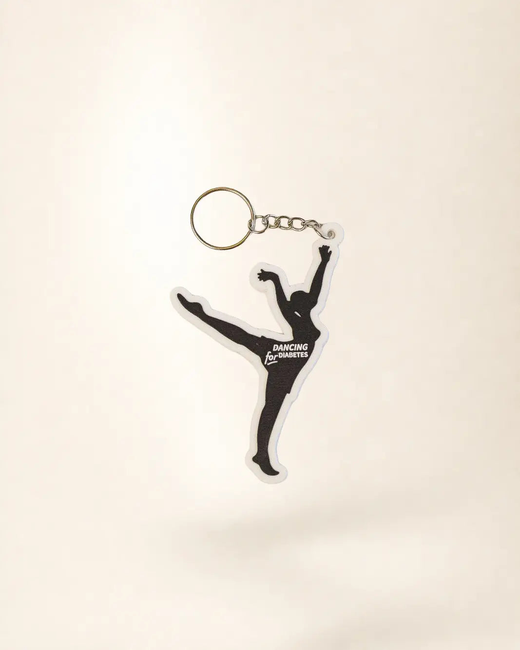 Keychain with a dancing figure design on a light beige background