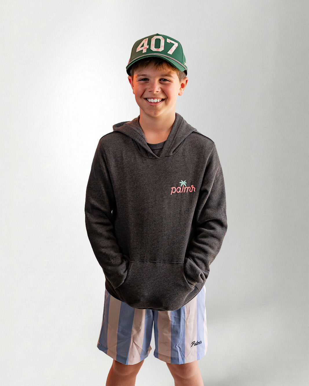 Person wearing a hoodie with a Palmr logo, standing against a plain background.