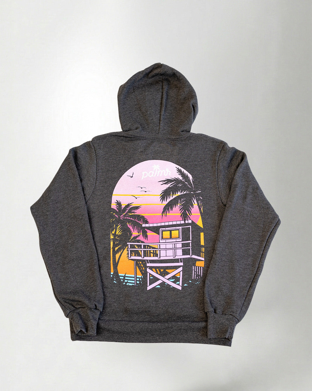 hoodie with a sunset and palm tree design on the back, standing against a plain background.